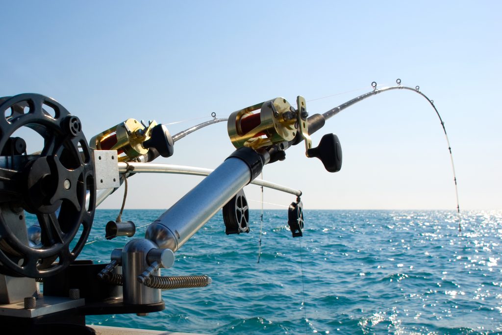 Fishing rod spinning with the line close-up. Fishing rod in rod holder in  fishing boat due the fishery day at the sunset. Fishing rod rings. Fishing  tackle. Fishing spinning reel. Photos