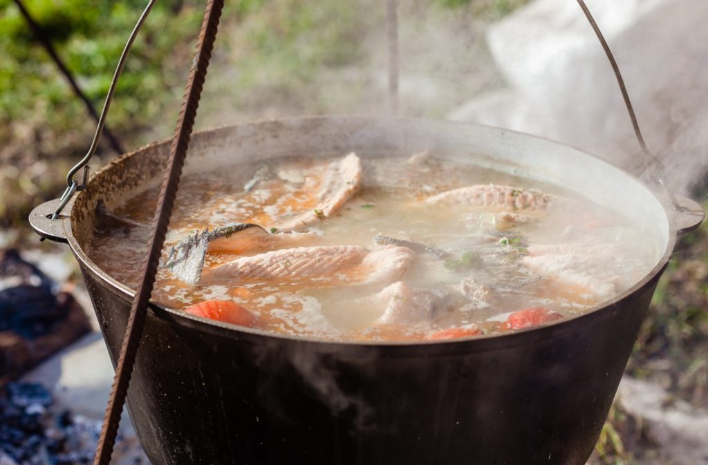 kettle cooking fish while camping